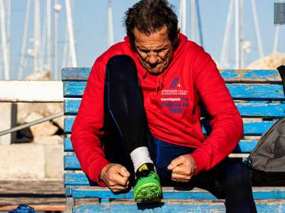 Mentre chiacchieriamo Alberto si prepara per iniziare il suo allenamento. Lo vediamo quindi intento ad allacciarsi le scarpe su una panchina posizionata davanti alla pista